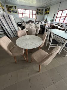 Set masa rotunda cu 4 scaune tapitate cu stofa de culoare cappuccino.